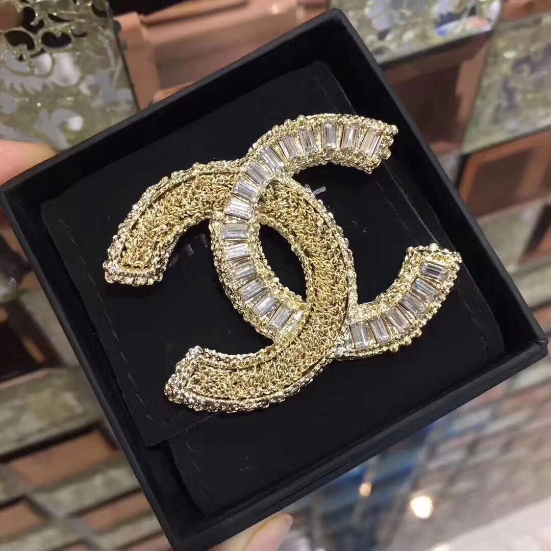 Signature Emblem Brooch in Polished Metal-Tone close-up view