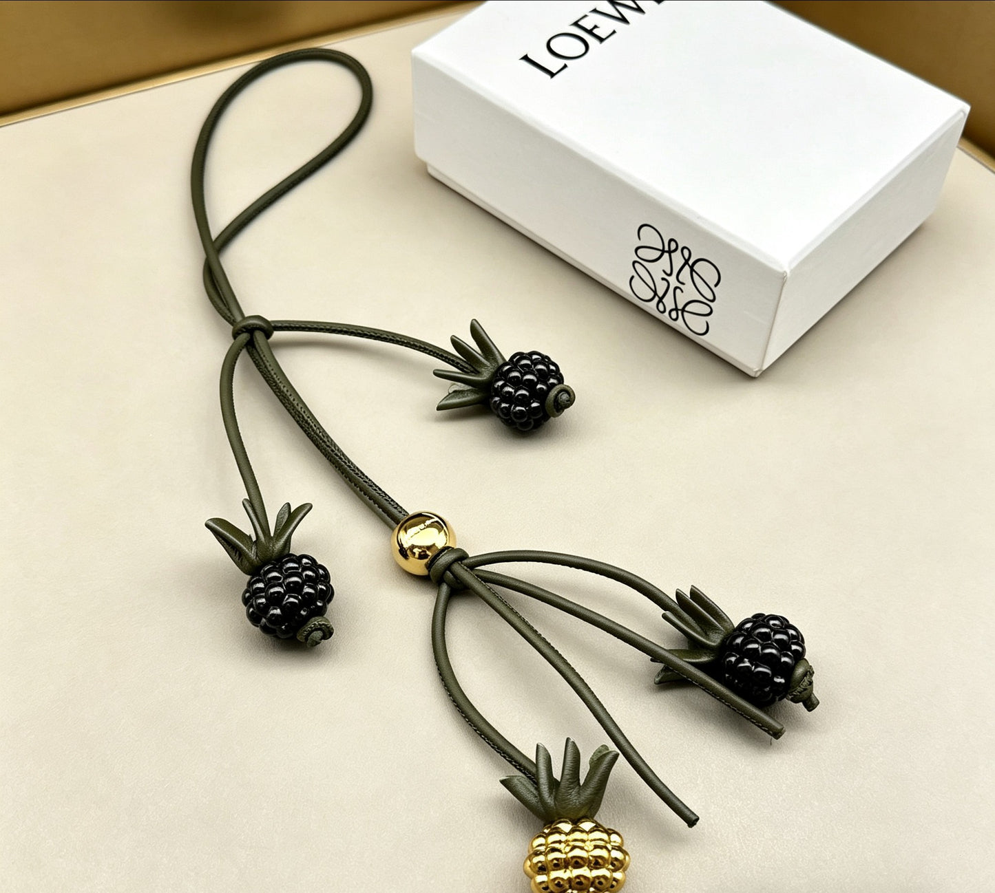 Graphic Emblem Bag Charm in Polished Metal-Tone with Leather Detail – Design 02 front view