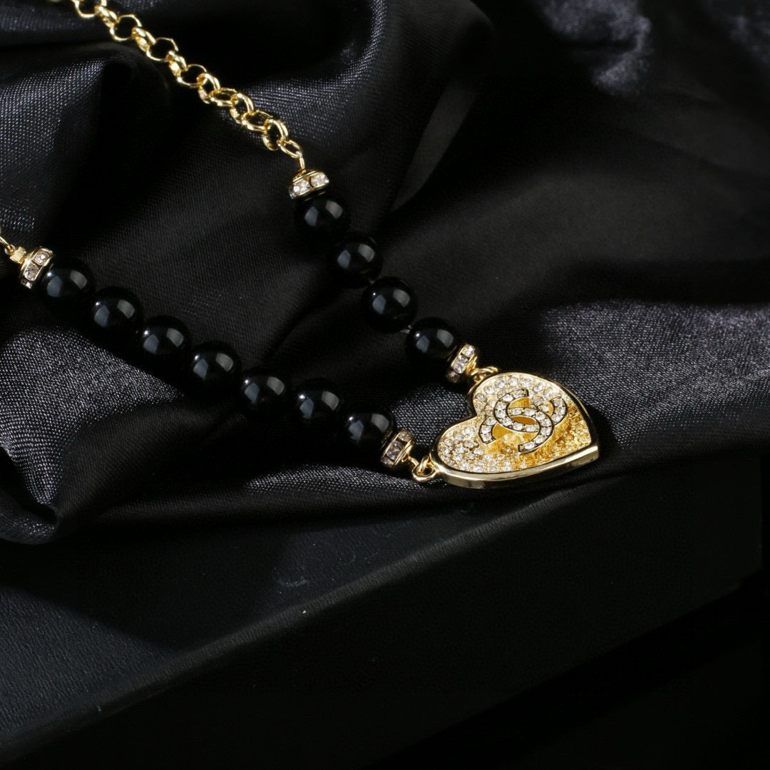 Double-C Emblem Pendant Necklace in Gold-Tone – Heart Detail styled product view