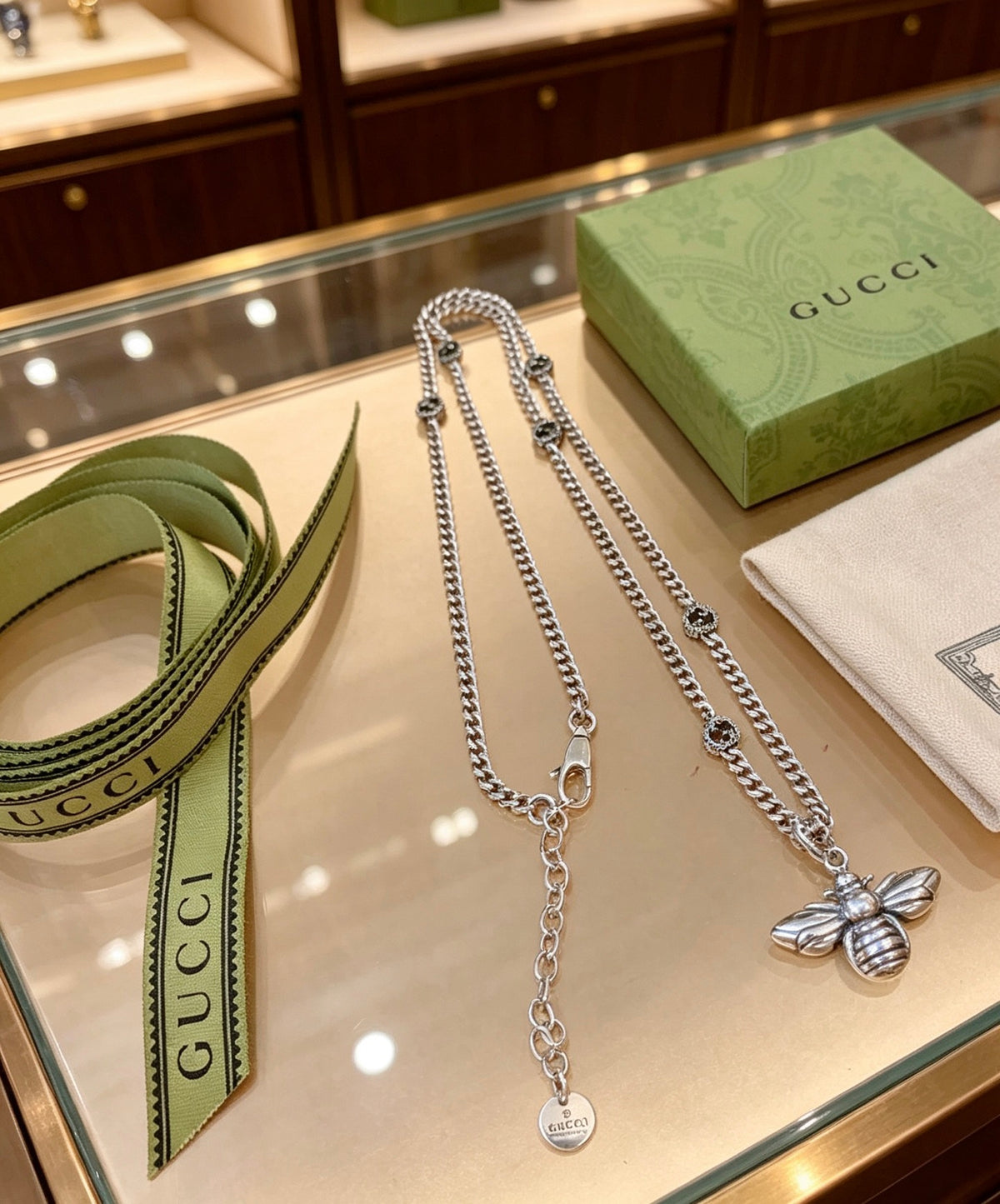 Double-G Emblem Pendant Necklace in Polished Metal-Tone – Bee Detail close-up detail