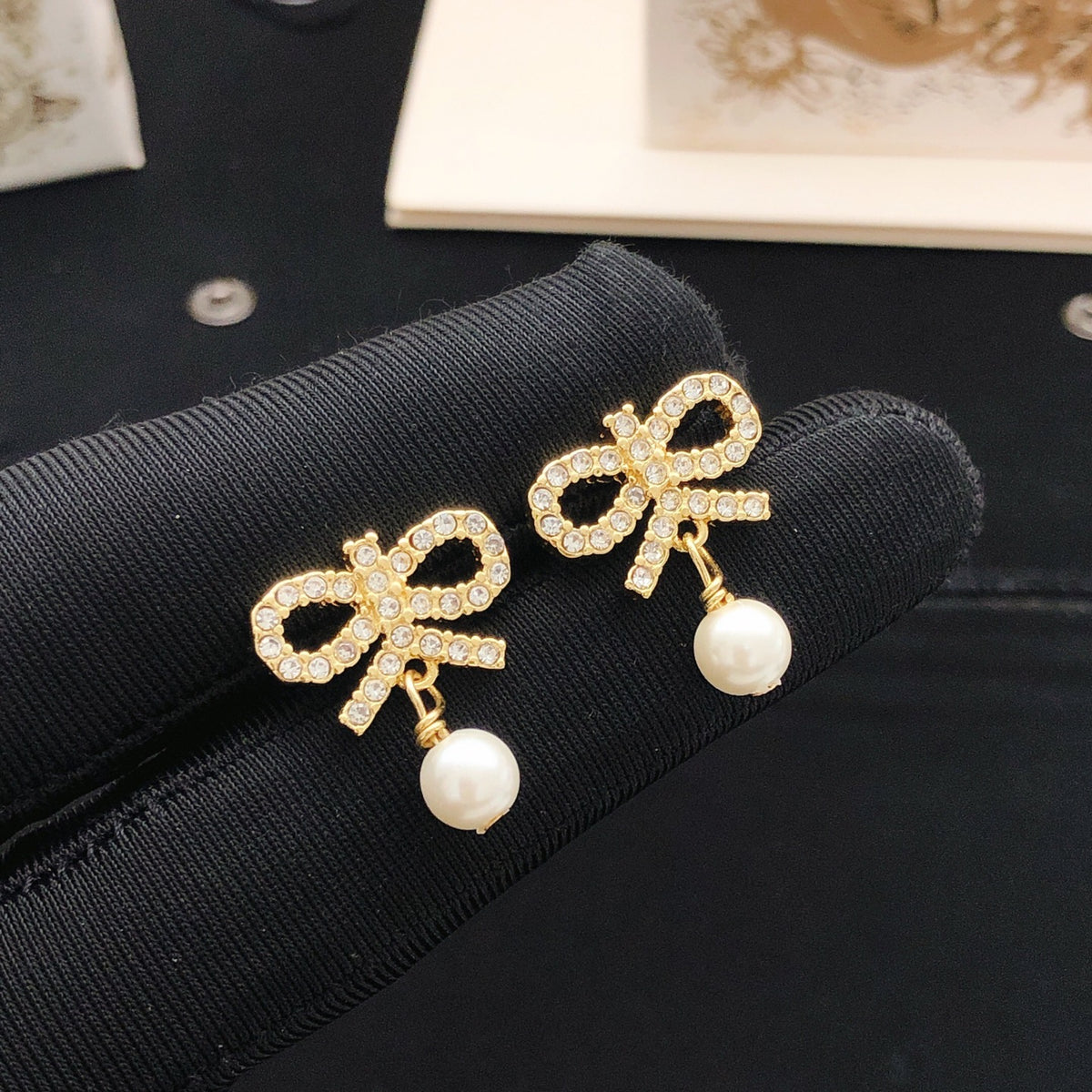 Bow & Butterfly Motif Stud Earrings in Polished Metal-Tone with Pearl-Style Detail detail view