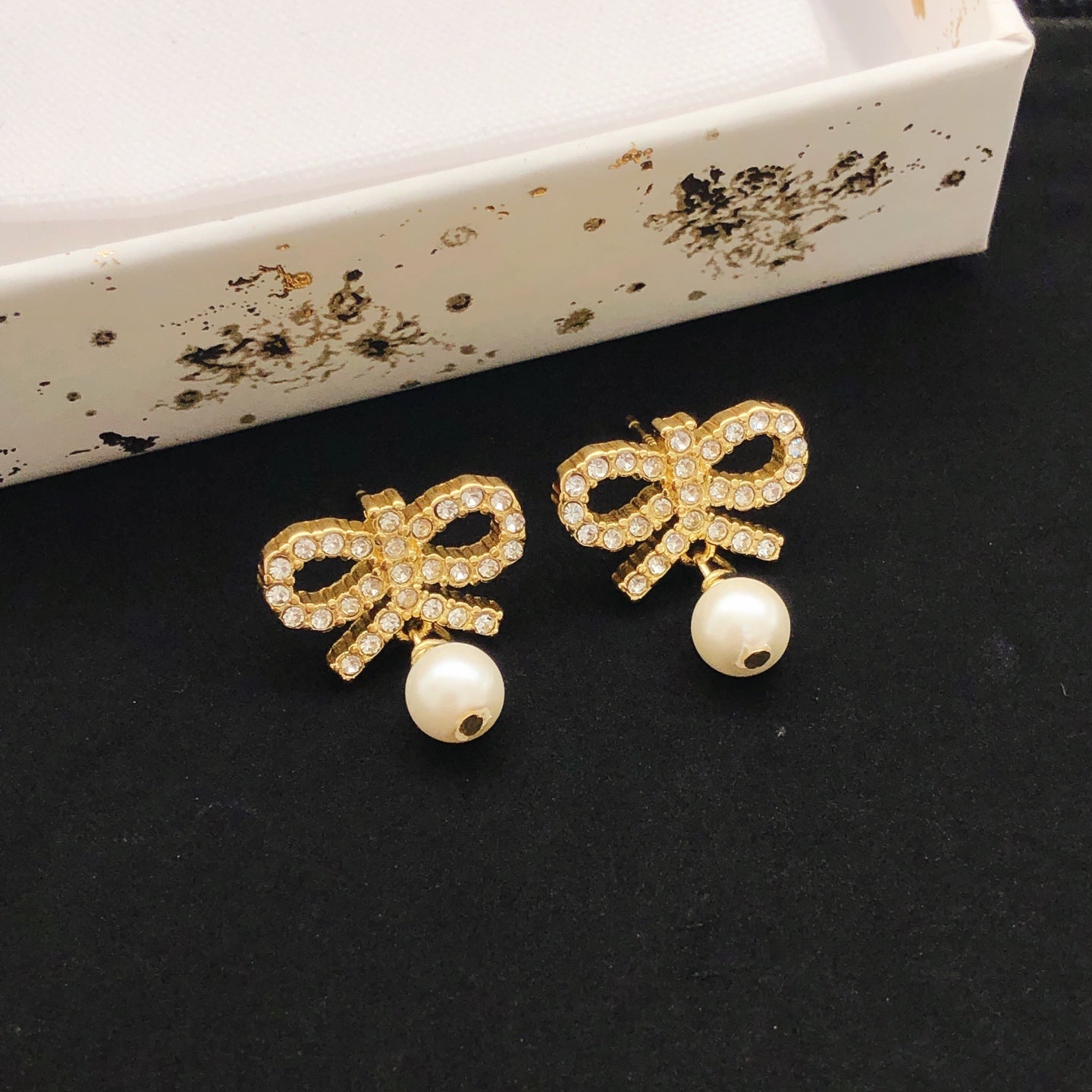 Bow & Butterfly Motif Stud Earrings in Polished Metal-Tone with Pearl-Style Detail close-up detail